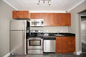 Kingston apartment for rent - a kitchen with stainless steel appliances and wooden cabinets