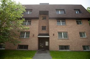 Kingston apartment for rent - the front of a brick building with a sidewalk in front