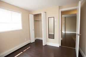 Kingston apartment for rent - a bedroom with a mirror and a hallway to a closet