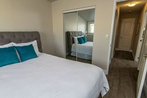 Kingston apartment for rent - A bedroom with a large bed and a mirrored closet door.