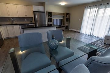 Kingston apartment for rent - A modern living room with a glass table and grey chairs.