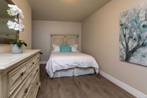 Amherstview apartment for rent - A bedroom with a bed, dresser, and painting.