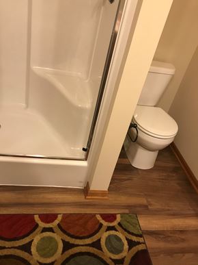 Lincoln house for rent - A white toilet sits next to a white shower door in a bathroom.