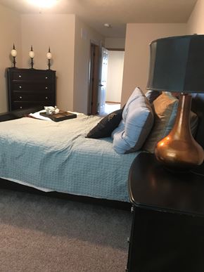 Lincoln house for rent - A bedroom with a bed, nightstand, lamp, and pillows.