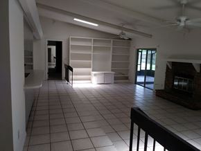 Winter Springs house for rent - A room with a fireplace and a ceiling fan.