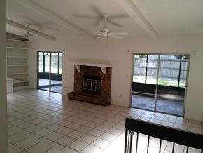 Winter Springs house for rent - A living room with a fireplace and sliding glass doors.