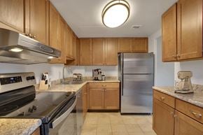 Denver apartment for rent - a kitchen with stainless steel appliances and wooden cabinets