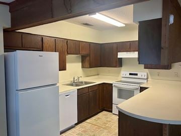 Beaufort - Available Now apartment for rent - A kitchen with white appliances and brown cabinets.