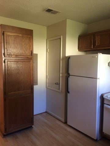 Beaufort - Coming Available 6/30/26 apartment for rent - A white refrigerator sits next to a wooden cabinet in a kitchen.