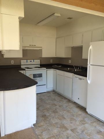 Beaufort - Coming Available 7/23/26 apartment for rent - A kitchen with white cabinets and a black counter.