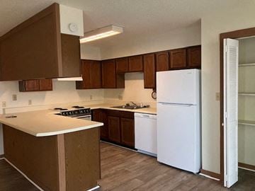 Beaufort - Coming Available 8/31/26 apartment for rent - A kitchen with white appliances and brown cabinets.