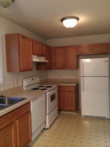 Beaufort - Available Now apartment for rent - a kitchen with white appliances and wooden cabinets