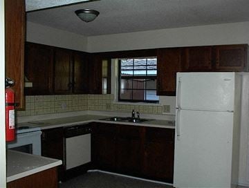 Beaufort - Coming Available 8/31/26 apartment for rent - A kitchen with a white refrigerator and brown cabinets.