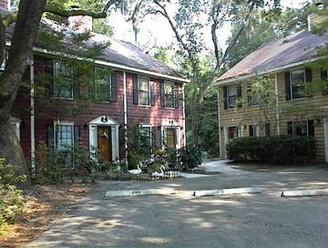 Beaufort - Coming Available 8/31/26 apartment for rent - A red house with a white door and windows is surrounded by trees.