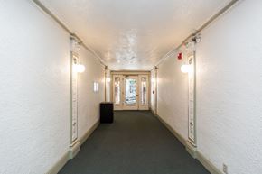 San Francisco apartment for rent - A long hallway with lights on both sides and a door at the end.
