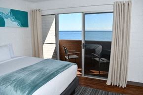 Hilo apartment for rent - a bedroom with a bed and a balcony overlooking the ocean