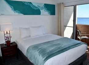 Hilo apartment for rent - a hotel room with a bed and a view of the ocean
