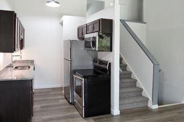 Oshkosh apartment for rent - a kitchen with a stove and a refrigerator and a staircase