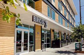 Portland apartment for rent - The image shows the front of a building named Burnside with a clear sky in the background.
