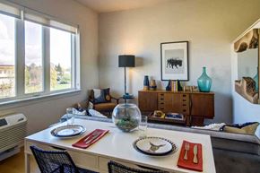 Portland apartment for rent - A dining room with a table set for two and a view of the outdoors through the window.