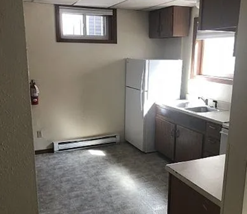 Fargo apartment for rent - A kitchen with a white refrigerator and a window.