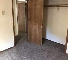 Fargo apartment for rent - A room with a wooden door and carpeted floor.