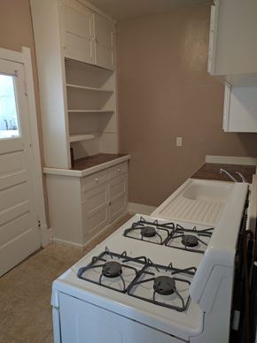 Cheyenne apartment for rent - an empty kitchen with a stove and a cabinet