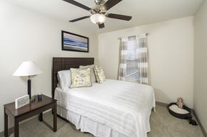 Marysville apartment for rent - A bedroom with a bed, nightstand, and a ceiling fan.