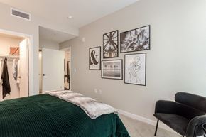 Pasadena apartment for rent - A bedroom with a green bedspread and a black chair.