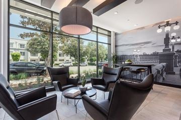 Pasadena apartment for rent - A modern living room with black leather chairs and a large window overlooking a street.