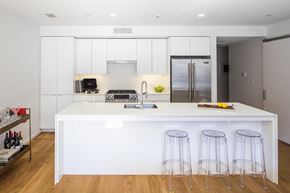 South Boston apartment for rent - a white kitchen with three bar stools in front of a white counter top