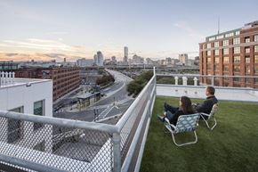 South Boston apartment for rent - two people sitting on chairs on a rooftop overlooking the city