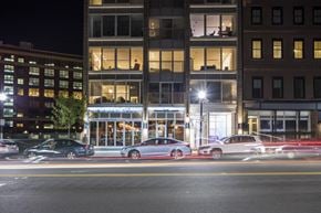 South Boston apartment for rent - a city street at night with cars parked in front of a building