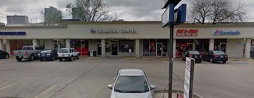 Houston apartment for rent - A white car is parked in front of a donation center.