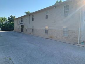 Decatur apartment for rent - A sunny day at the parking lot of a beige building.