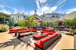 College Park apartment for rent - a lounge area with red couches and tables in a courtyard