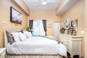 Fort Myers apartment for rent - bedroom with fan, large window, and model furnishings