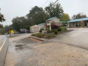 Pea Ridge apartment for rent - A wet street with a yellow sign on the side.
