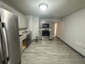 Pea Ridge apartment for rent - A kitchen with a refrigerator, microwave, oven, and a chair.