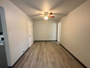 Pea Ridge apartment for rent - A room with a ceiling fan and light fixture, wooden flooring, and two doors.