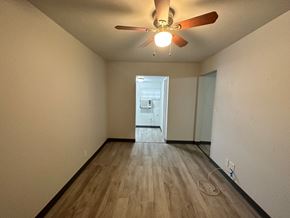 Pea Ridge apartment for rent - A room with a ceiling fan and wooden flooring.