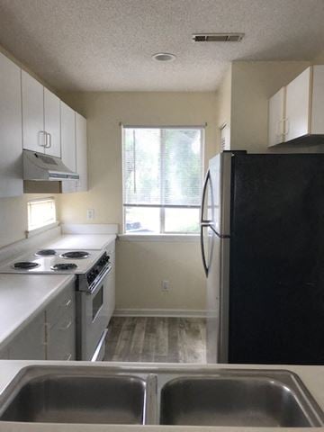 Beaufort - Coming Available 6/3/26 apartment for rent - A black refrigerator sits in a kitchen with a stove and sink.