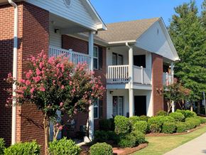 Moultrie apartment for rent - a building with a porch and a flowering tree in front of it