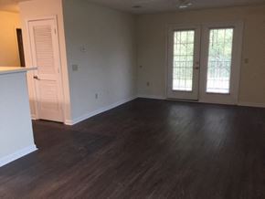 Douglas apartment for rent - an empty living room with wooden floors and white doors