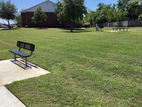 Douglas apartment for rent - a park bench sitting in the grass in front of a building
