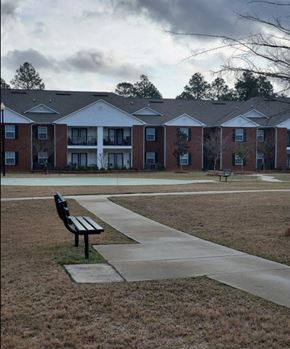 Vidalia apartment for rent - a bench on a sidewalk in front of a building