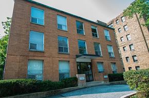 Washington apartment for rent - A brick building with a pool in front.