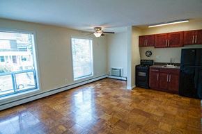 Washington apartment for rent - A kitchen with wooden floors and black appliances.