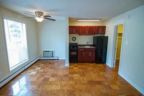 Washington apartment for rent - A kitchen with wooden floors and black appliances.