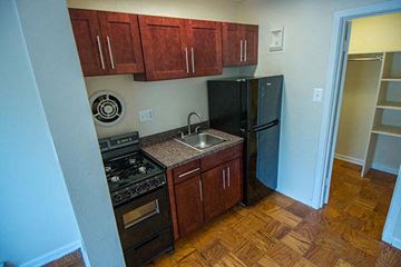 Washington apartment for rent - A kitchen with wooden cabinets and a black refrigerator.